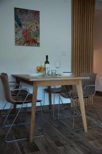 a wooden table with chairs and a bottle of wine at New Aesthetic Haven Hedonica 6 Apartment in Vrdnik in Vrdnik