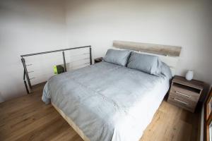 1 dormitorio con cama y mesita de noche en Studio Los Manzanos en San Carlos de Bariloche