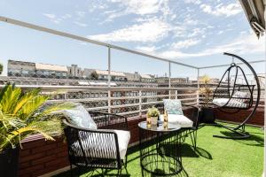 einen Balkon mit Stühlen, einem Tisch und einer Schaukel in der Unterkunft Modern Apartments in Puerto Madero in Buenos Aires