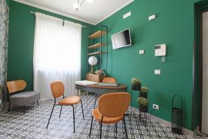 um quarto com uma mesa e cadeiras e uma parede verde em Malù - Bed & Breakfast em Agrigento