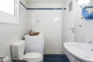 a white bathroom with a toilet and a sink at Athens cozy rooms walk to Acropolis in Athens