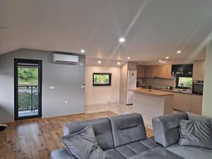 a living room with a couch and a kitchen at Apartment Hara, luxury lakeside suite with exquisite view in Jablanica