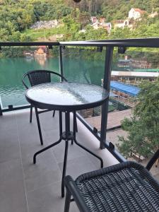 a table and chairs on a balcony with a view of a lake at Apartment Hara, luxury lakeside suite with exquisite view in Jablanica