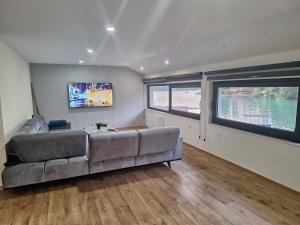 a living room with a couch and a flat screen tv at Apartment Hara, luxury lakeside suite with exquisite view in Jablanica