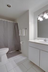 een witte badkamer met een toilet en een wastafel bij Modern Apartment At Crystal City With Gym in Arlington