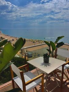 a table and chairs on a balcony with a view of a beach at SeaHomes Vacations - MARINA BOUTIQUE design in Santa Susanna