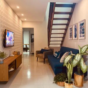 a living room with a blue couch and stairs at Bangalô 39 in Tamandaré