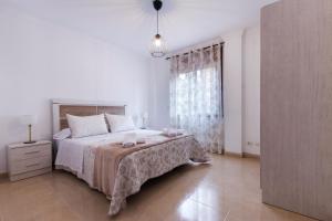 ein weißes Schlafzimmer mit einem Bett und einem Fenster in der Unterkunft El Brezo in Tegueste