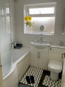 a bathroom with a sink and a toilet and a window at budget private rooms close to city centre and airport in Birmingham