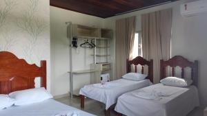 a bedroom with two beds and a window at Hotel Indiana in Paragominas