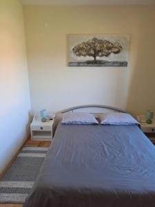 um quarto com uma cama com uma árvore na parede em Rooms Goriš em Goriš