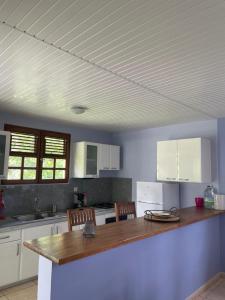 a kitchen with white cabinets and a wooden counter top at LA CAZ TRANKIL in La Trinité
