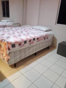 um quarto com uma cama com um cobertor xadrez em Lar da Galega Espinheiro no Recife