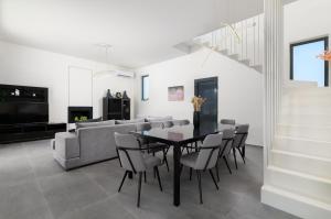 a dining room and living room with a table and chairs at Villa Korali in Pastida