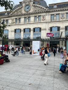 un gran edificio con gente caminando delante de él en Le Marengo: Charmant, Rénové, Terrasse, Parking privé, en Toulouse