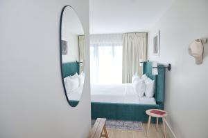 Habitación de hotel con cama y espejo en Hotel Moraine en Greenport