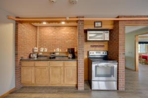 una cucina con muro di mattoni, piano cottura e forno a microonde di Natures Paradise Rustic Retreat in Wisconsin! 