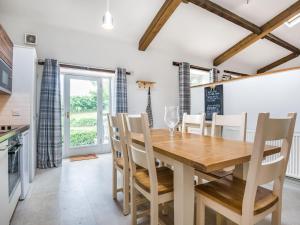 Saint Weonards的住宿－Teal Barn Annexe，厨房以及带木桌和椅子的用餐室。