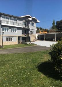 a large white building with a grassy field in front of it at Hotel Sebreñu in Sebreño