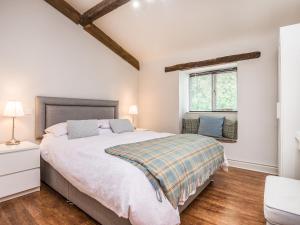 a bedroom with a large bed and a window at Teal Barn Annexe in Saint Weonards