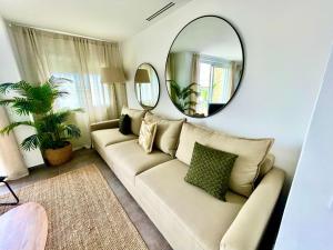 a living room with a white couch and a mirror at SeaHomes Vacations - MARINA BOUTIQUE design in Santa Susanna