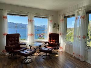 - un salon avec deux chaises, une table et des fenêtres dans l'établissement Bestefarhuset, à Hakkstabben