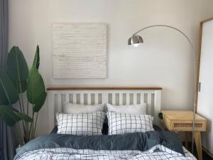 Dormitorio con cama, lámpara y planta en Nobita House toà S202 Vinhome Grand Park full nội thất view sông - Netflix en Gò Công