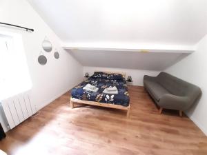 ein Schlafzimmer mit einem Bett und einem Sofa darin in der Unterkunft Résidence du Houx - 6 (Astérix, Aéroport CDG...) in Survilliers