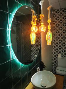 baño con espejo, lavabo y luces en Hotel Pepo, en Benifallet