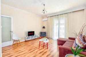 a living room with a couch and a tv at Grand Apartment Next to Center 3bd 110sqm in Thessaloniki