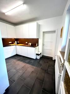 a kitchen with white cabinets and a tile floor at Natur&Meer: Ferienwohnung im idyllischen Landhaus in Ahrenshagen