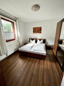 a bedroom with a white bed and a large window at Natur&Meer: Ferienwohnung im idyllischen Landhaus in Ahrenshagen