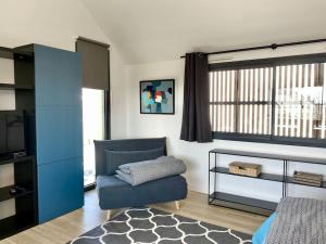 sala de estar con silla azul y TV en Magnifique T2 neuf, proche gare, parking facile en Vannes