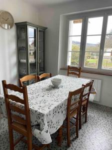 comedor con mesa, sillas y ventanas en Maison familiale 8 p en vallée de Dordogne - Lot, en Tauriac