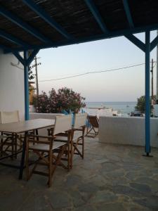 una mesa y sillas en un patio con vistas al océano en Asimina's beach house, en Ándros
