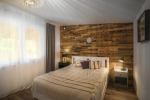 1 dormitorio con 1 cama y pared de madera en Sławica Inn domek letniskowy nad jeziorem en Sławica