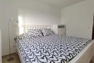 um quarto com uma cama com um edredão preto e branco em Brisa del mar em La Santa