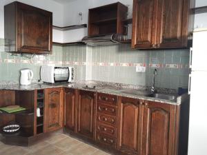 a kitchen with wooden cabinets and a sink at Brisa del mar in La Santa