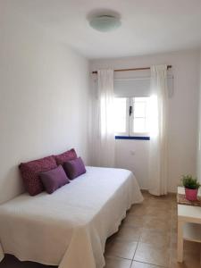 Brisa del mar في لا سانتا: غرفة نوم مع سرير أبيض كبير مع وسائد أرجوانية