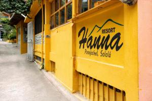 un bâtiment jaune avec un panneau sur son côté dans l'établissement Hotel & Restaurante Hanna Resort, à Panajachel