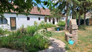 un jardin en face d'une maison blanche dans l'établissement EVA HOUSE, à Pačir