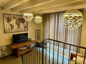 ein Wohnzimmer mit zwei Hängelampen und einem TV in der Unterkunft Corte Lavarini The Magic At Sight in Fumane