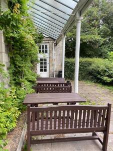 a wooden picnic table sitting under a pergola at Marle Hall - Dorm Rooms (Blue) in Llandudno Junction