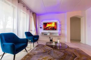 a living room with two blue chairs and a tv at Havens corner in Sandton