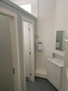 a white bathroom with a sink and a mirror at Marle Hall - Dorm Rooms (Blue) in Llandudno Junction