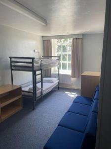 a room with two bunk beds and a couch at Marle Hall - Dorm Rooms (Blue) in Llandudno Junction