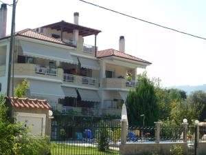 a large white building with a fence in front of it at Villa Thassos Paradise in Limenas