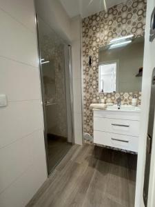 a bathroom with a sink and a shower and a mirror at Ascensor à Vista in Nazaré +15 photos
