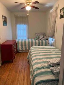 Charming Upstairs 2 Bdrm في Stockton: غرفة نوم بسريرين ومروحة سقف