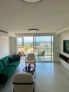 a living room with a green couch and chairs at Suite In White in ‘Akko